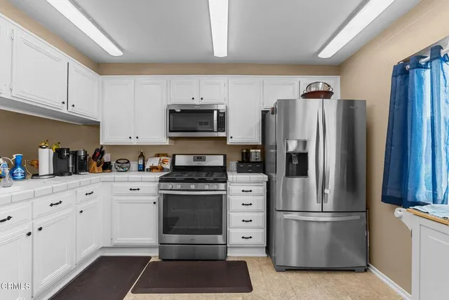 a kitchen with cabinets stainless steel appliances and a counter space