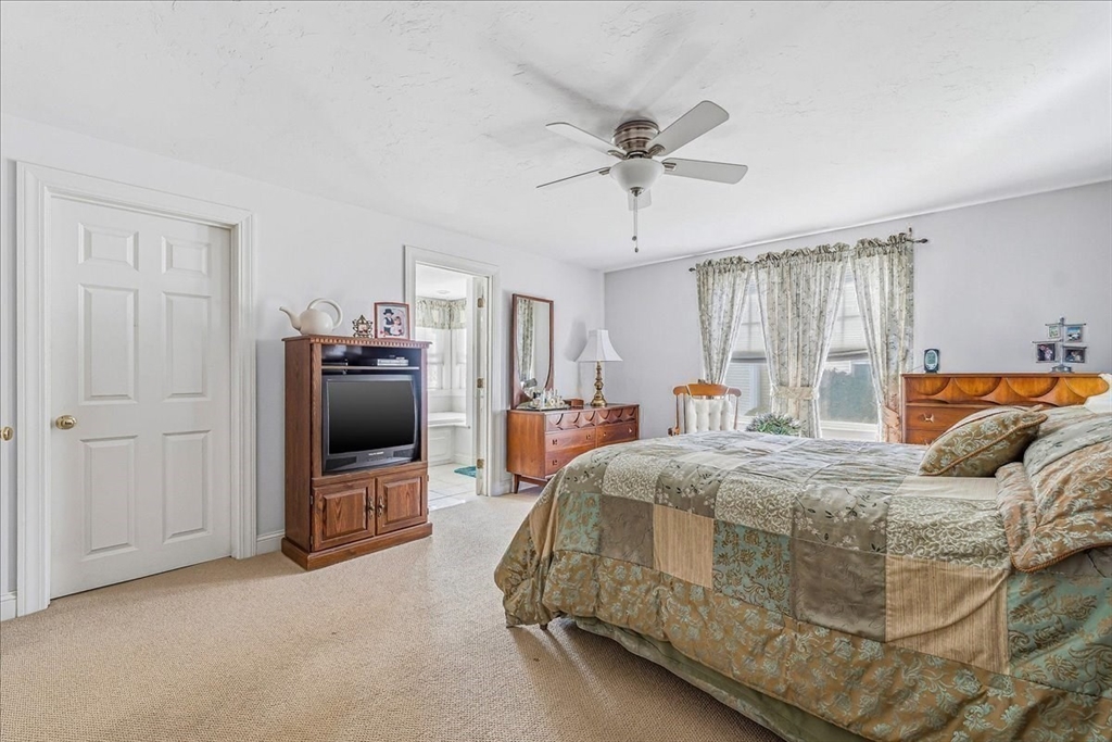 4 Old Field Road, Unit 4 Plymouth, MA 02360 - Photo 25 of 42 a spacious bedroom with a bed and a chandelier