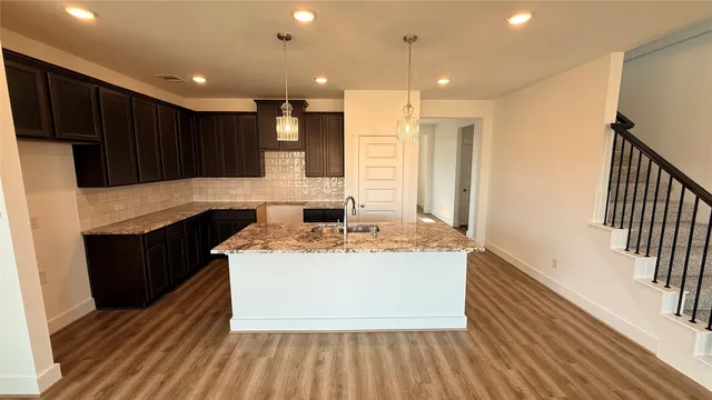 a kitchen with kitchen island a sink stainless steel appliances and cabinets