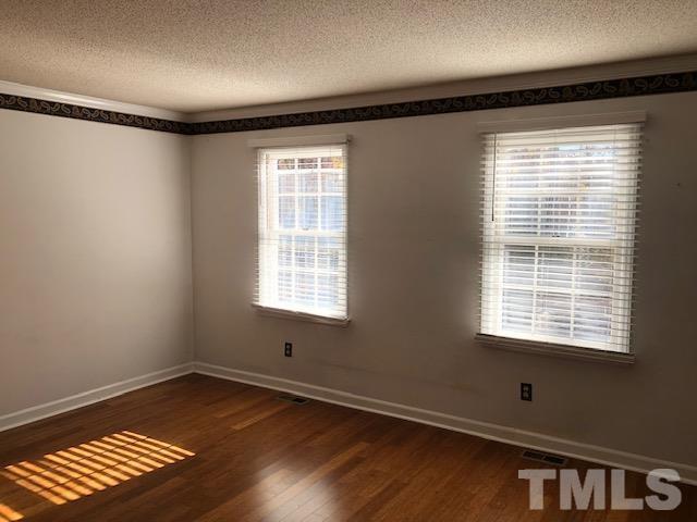 2804 Steeplechase Court Raleigh, NC 27613 - Photo 9 of 41 a view of an empty room with wooden floor and a window