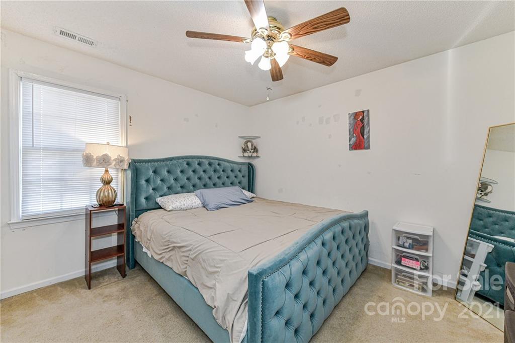 9043 Silver Coach Lane Charlotte, NC 28273 - Photo 23 of 32 a bedroom with a bed and a chandelier