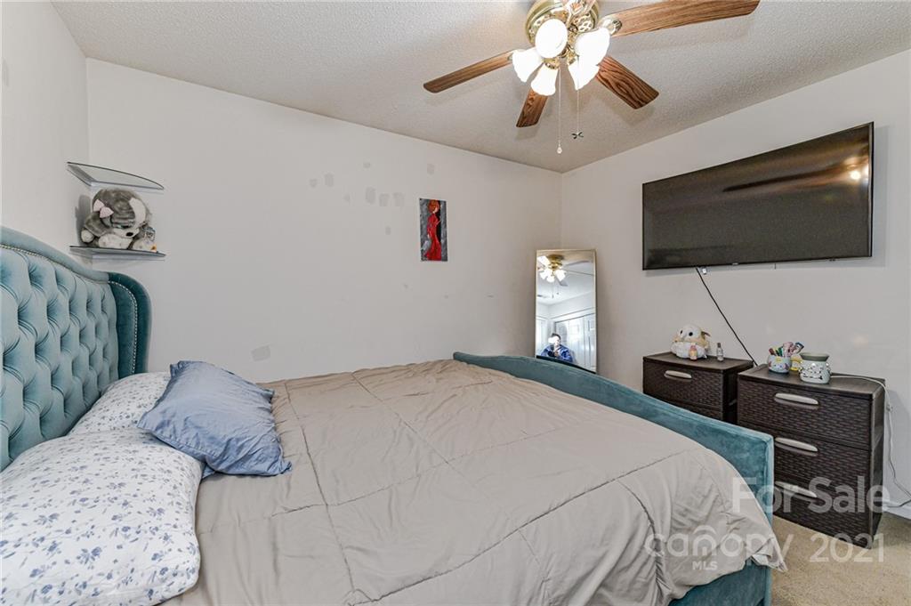 9043 Silver Coach Lane Charlotte, NC 28273 - Photo 24 of 32 a bedroom with a bed and a flat screen tv