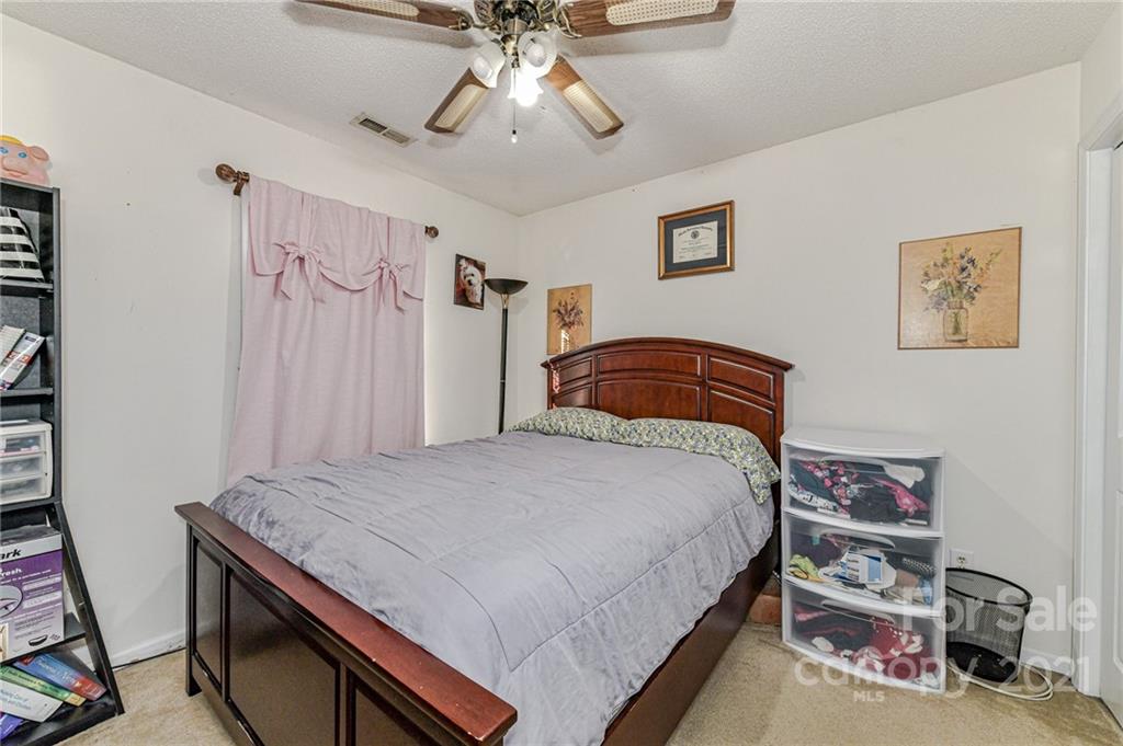 9043 Silver Coach Lane Charlotte, NC 28273 - Photo 26 of 32 a bedroom with a bed and a chandelier