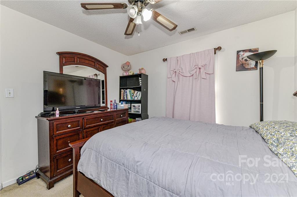 9043 Silver Coach Lane Charlotte, NC 28273 - Photo 27 of 32 a bedroom with a bed and a flat screen tv