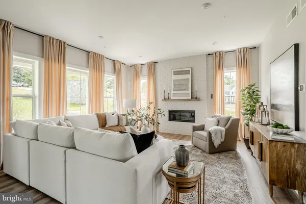 a living room with furniture fireplace and a large window