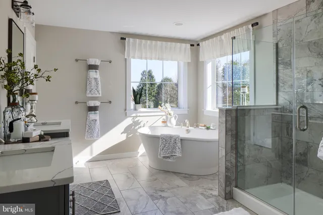 a spacious bathroom with a tub sink and mirror