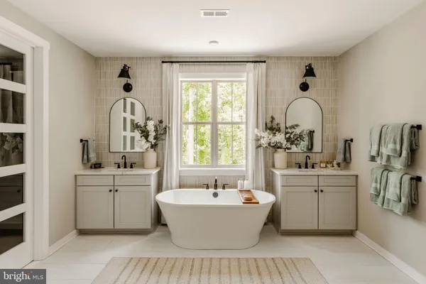 a large white kitchen with sink a window and stainless steel appliances