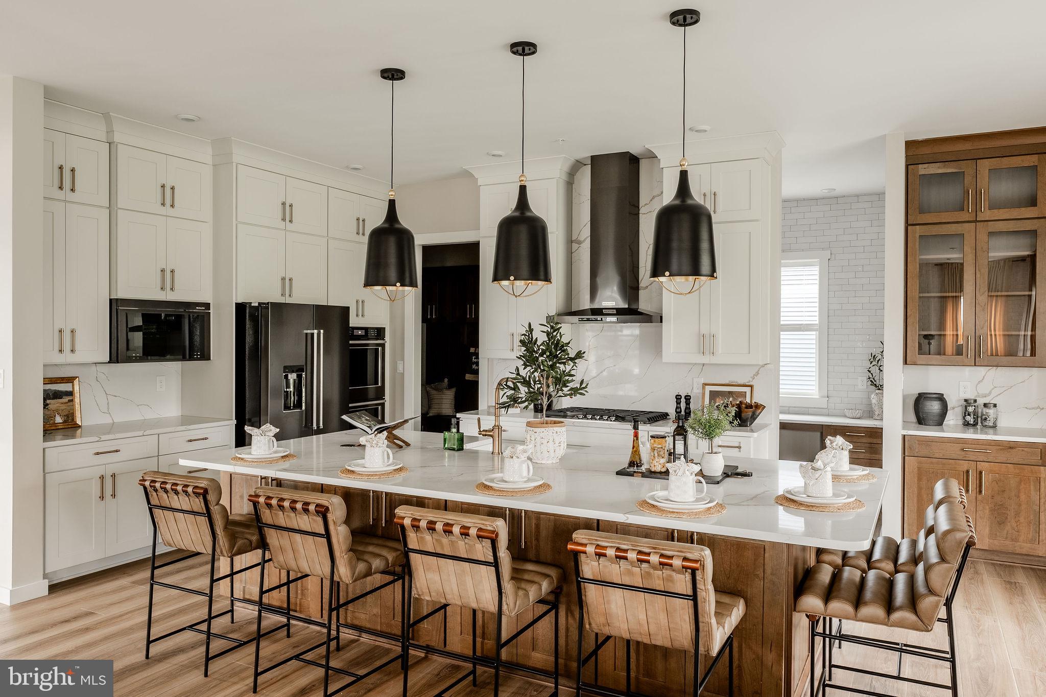 707007728 Hook Road, Unit COVINGTON Westminster, MD 21157 - Photo 10 of 48 a kitchen with stainless steel appliances kitchen island granite countertop a dining table chairs and white cabinets