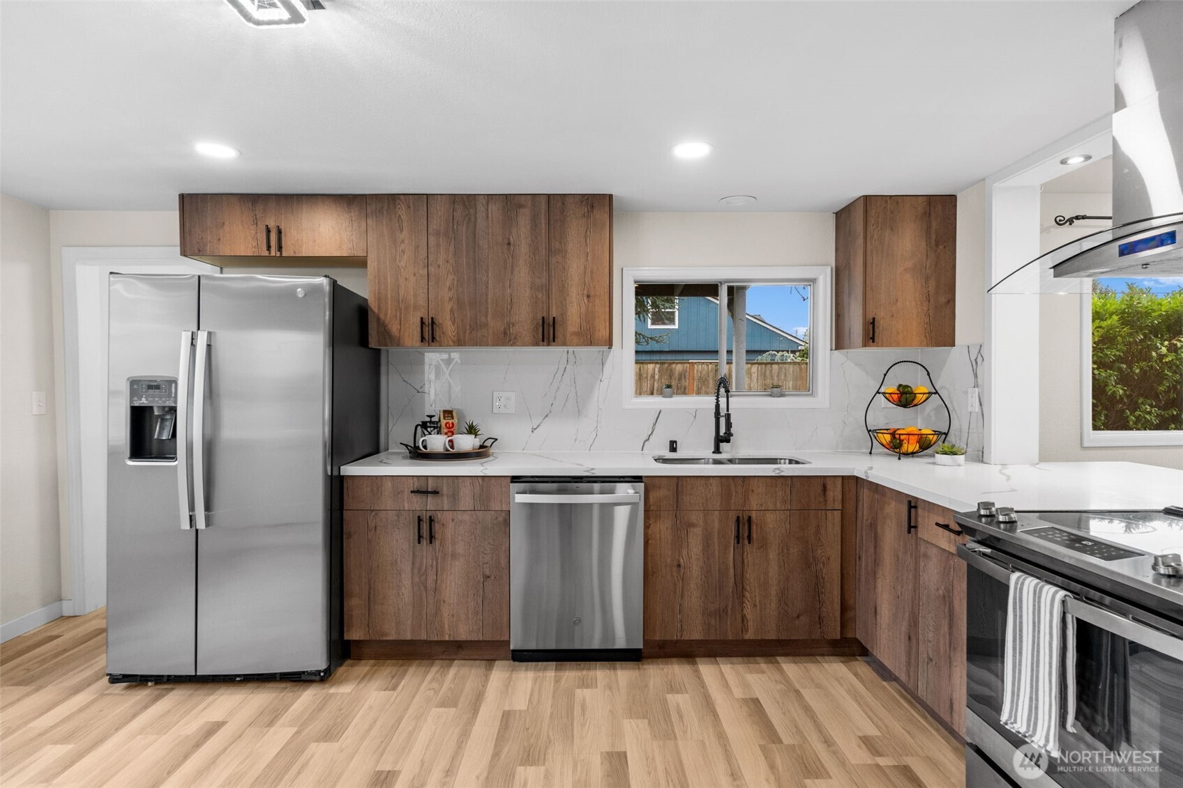 3215 North Tyler Street Tacoma, WA 98407 - Photo 9 of 40 a kitchen with stainless steel appliances granite countertop a refrigerator a sink dishwasher a stove with wooden floors and cabinets