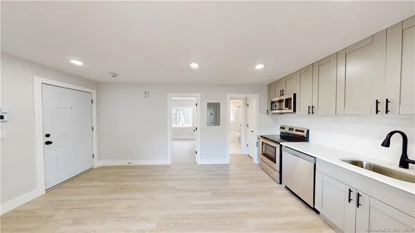 a large kitchen with stainless steel appliances lots of counter space and wooden floor