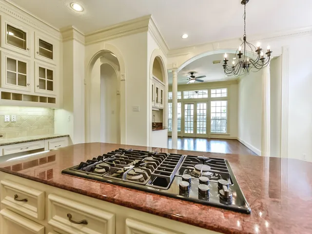 a kitchen with stainless steel appliances granite countertop a stove and a wooden cabinets