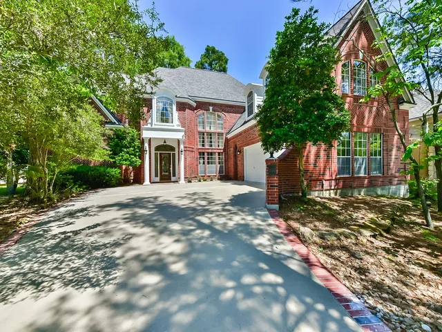 a front view of a house with a tree