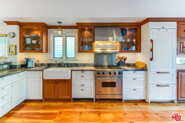 a kitchen with stainless steel appliances granite countertop a stove a sink and a refrigerator