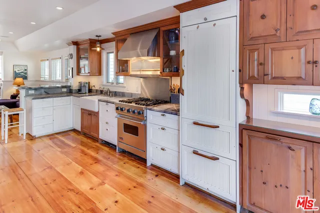 a kitchen with a stove top oven and white cabinets