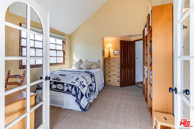 a bedroom with a bed next to a window