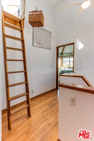 a view of an empty room with stairs and wooden floor