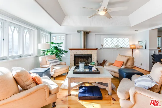a living room with furniture fireplace and a large window