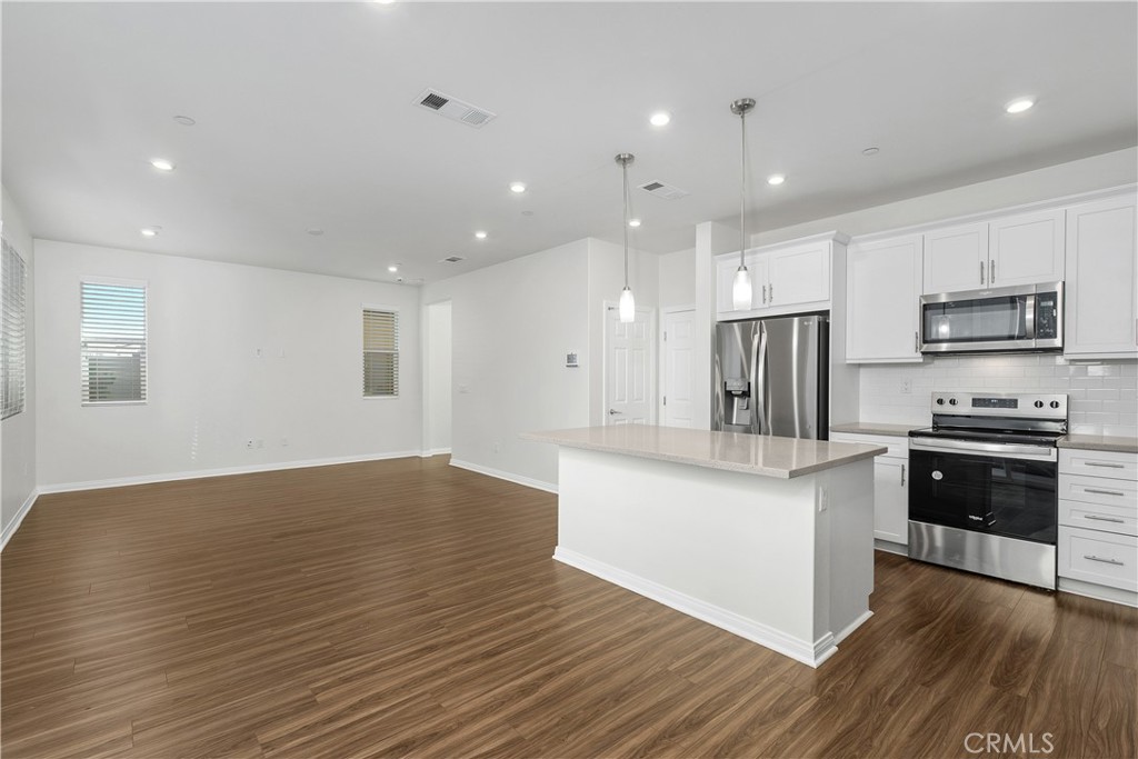 913 Helena Ridge Lake Elsinore, CA 92530 - Photo 12 of 38 a kitchen with stainless steel appliances granite countertop a refrigerator a stove top oven a sink and dishwasher with wooden floor