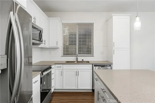 a kitchen with stainless steel appliances granite countertop a sink a stove and a refrigerator