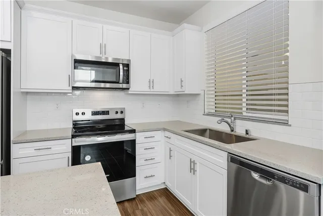 a kitchen with stainless steel appliances white cabinets and a sink