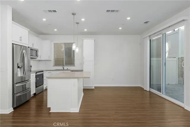 a kitchen with stainless steel appliances granite countertop a refrigerator and a sink