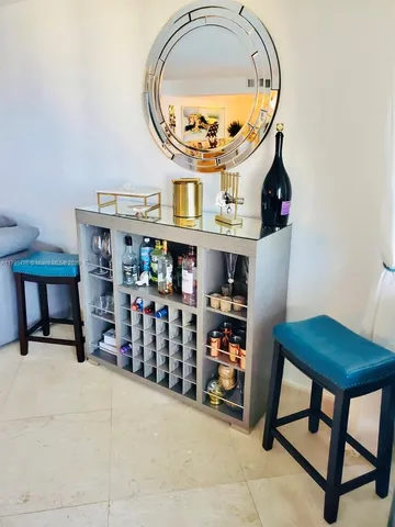 a kitchen with stainless steel appliances granite countertop a refrigerator a sink dishwasher and a dining table with wooden floor