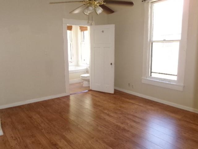 446 Merrick Street Shreveport, LA 71104 - Photo 13 of 16 an empty room with wooden floor fan and windows