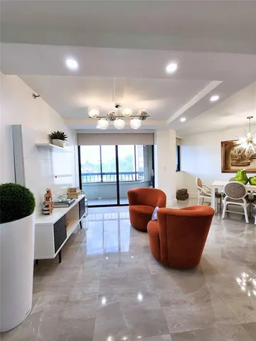a large living room with large windows and a chandelier