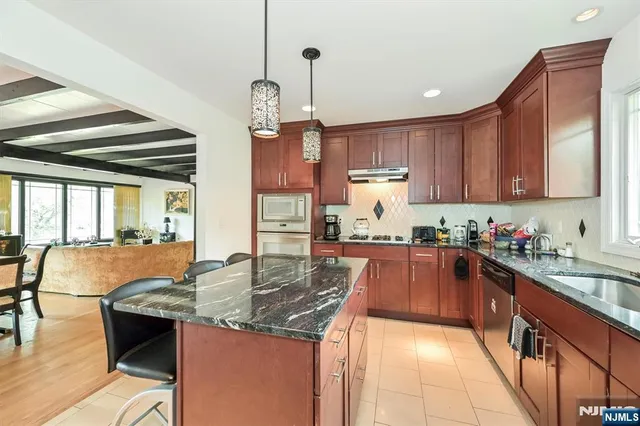 a kitchen with granite countertop a sink counter top space cabinets and stainless steel appliances