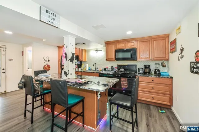 a kitchen with stainless steel appliances granite countertop table chairs sink and cabinets