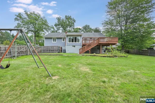 a view of a house with a backyard and a tree