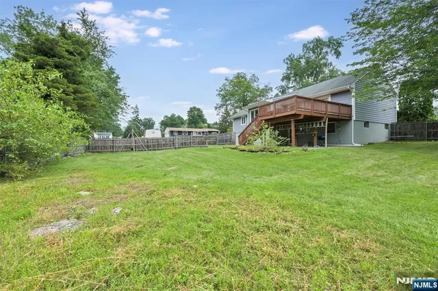 a view of a house with a yard potted plants and large tree