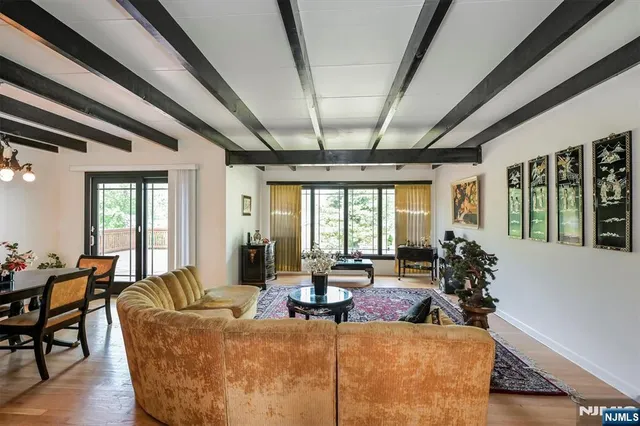a living room with furniture large window and potted plants