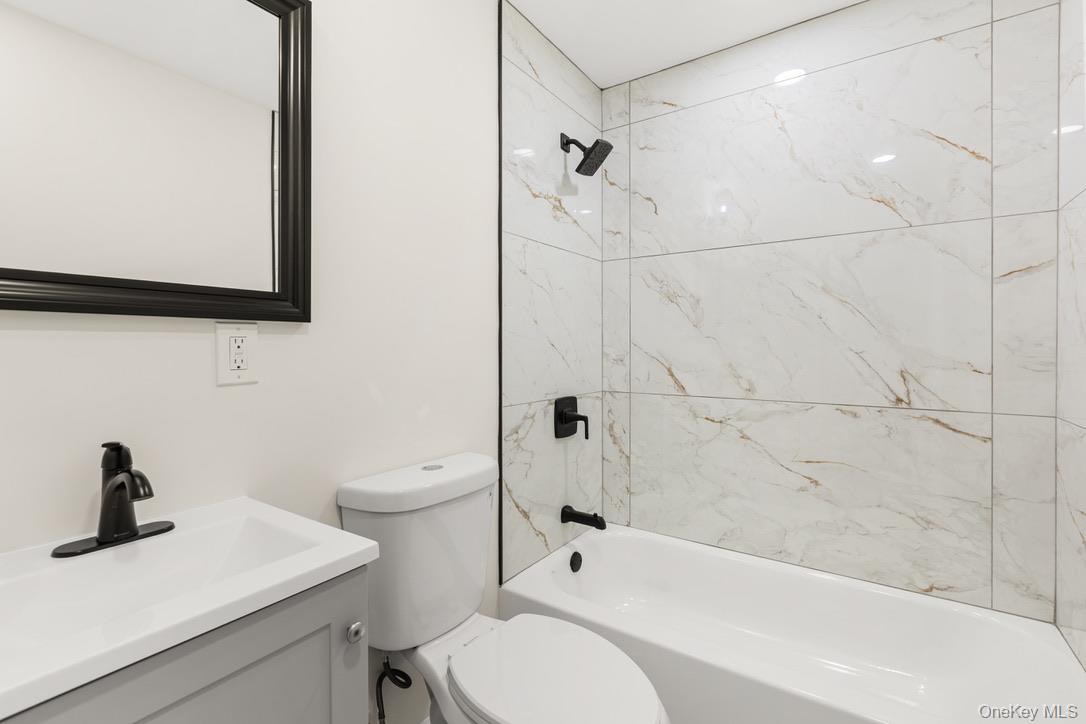 31 Grove Street Hempstead, NY 11550 - Photo 11 of 17 a bathroom with a bathtub shower sink vanity and toilet