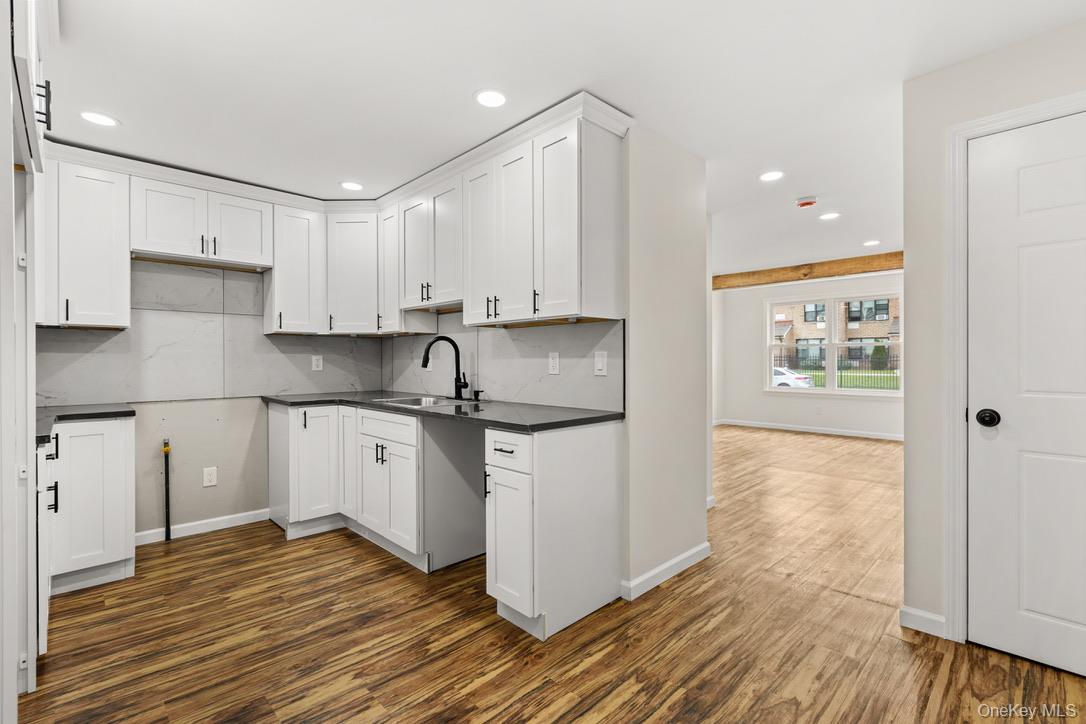 31 Grove Street Hempstead, NY 11550 - Photo 7 of 17 a kitchen with granite countertop white cabinets and white appliances