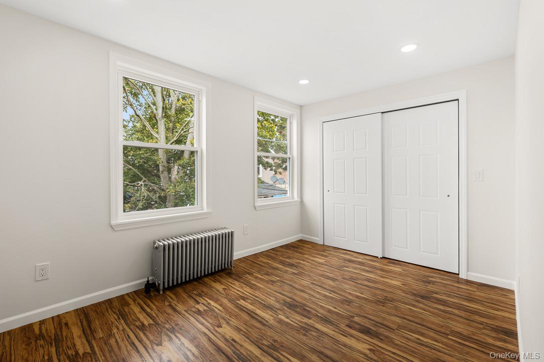 31 Grove Street Hempstead, NY 11550 - Photo 10 of 17 a view of an empty room with wooden floor and a window
