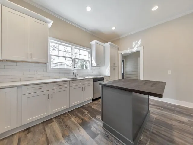 a kitchen with stainless steel appliances granite countertop a sink stove and cabinets