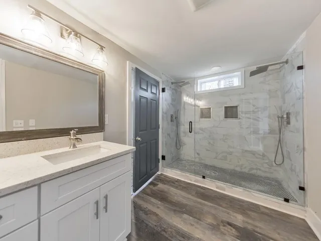 a bathroom with a shower sink and mirror