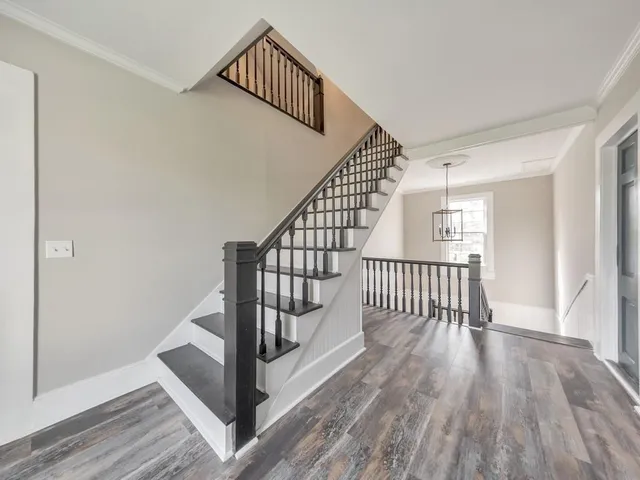 a view of a hallway with wooden floor and staircase