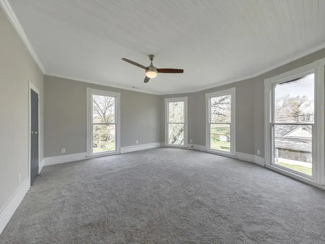 a view of a livingroom with a ceiling fan and window
