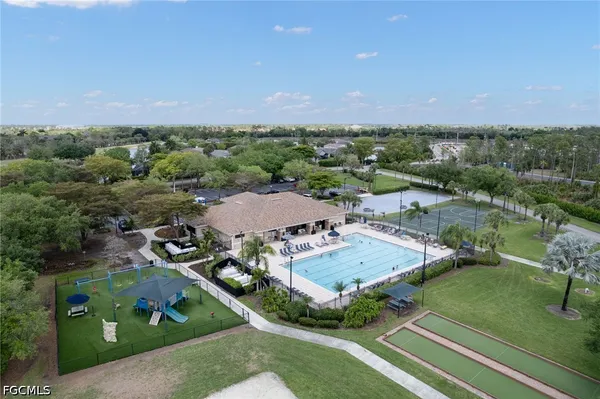 an aerial view of residential houses with outdoor space and trees