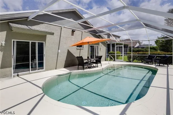 a view of a patio with a table and chairs under an umbrella