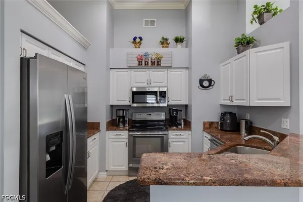 a kitchen with granite countertop a refrigerator stove and microwave