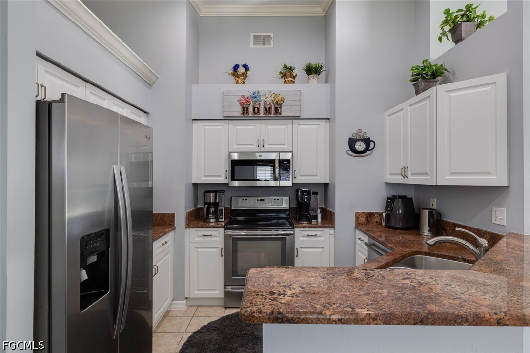 21711 Brixham Run Loop Estero, FL 33928 - Photo 8 of 32 a kitchen with granite countertop a refrigerator stove and microwave