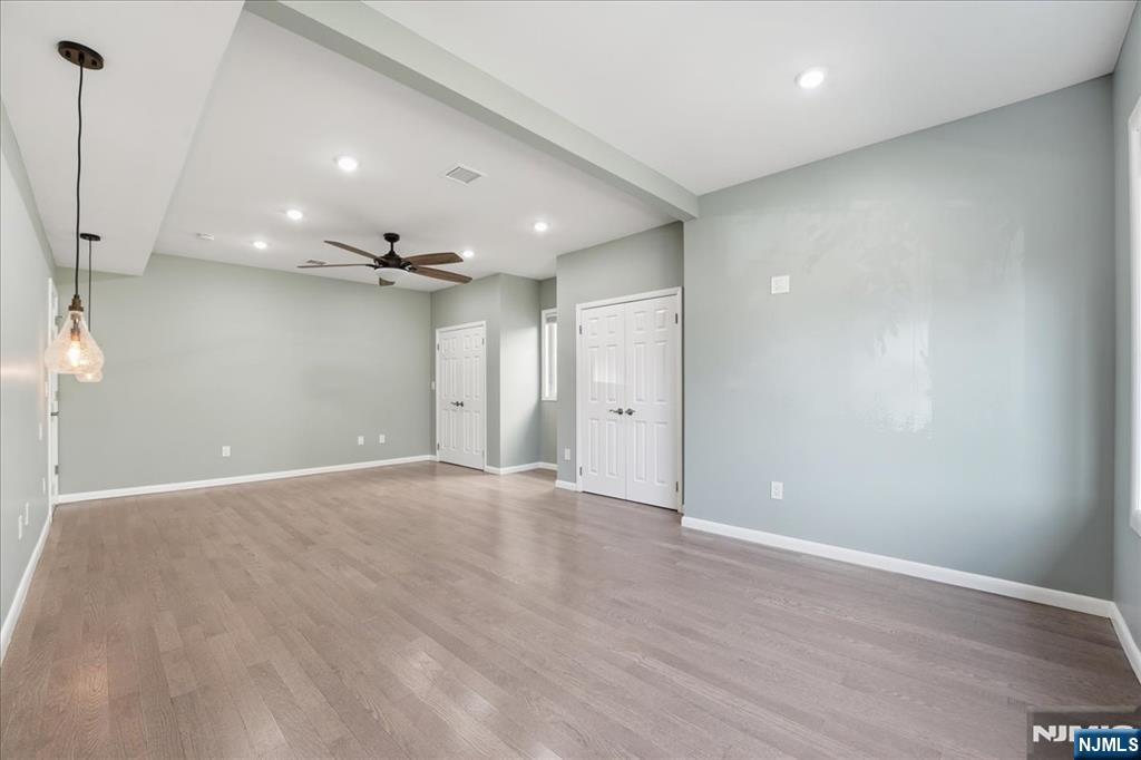 85 Beckwith Place Rutherford, NJ 07070 - Photo 16 of 49 an empty room with wooden floor and a ceiling fan