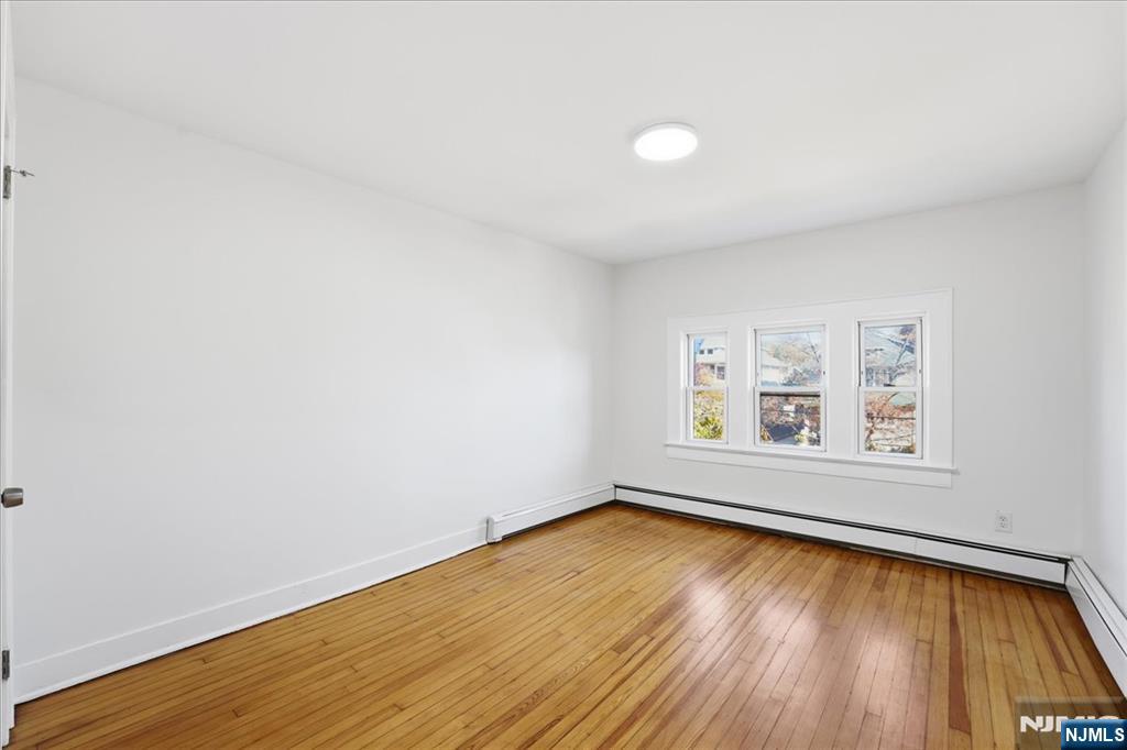 85 Beckwith Place Rutherford, NJ 07070 - Photo 27 of 49 an empty room with a window and wooden floor