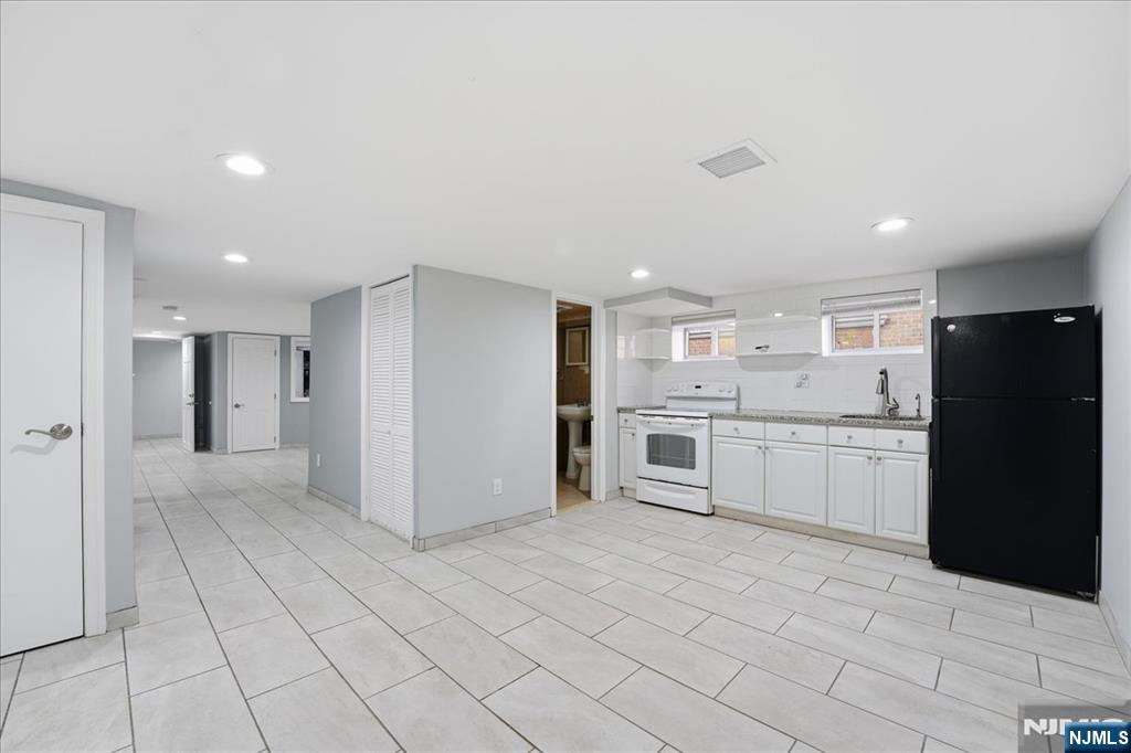 85 Beckwith Place Rutherford, NJ 07070 - Photo 35 of 49 a large white kitchen with a stove a refrigerator and white cabinets