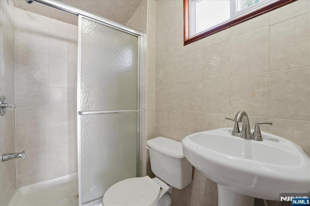 85 Beckwith Place Rutherford, NJ 07070 - Photo 49 of 49 a white toilet sitting next to a bathroom sink