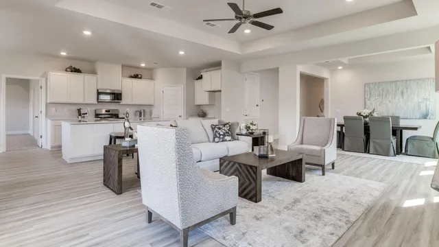 a living room with lots of furniture and kitchen view