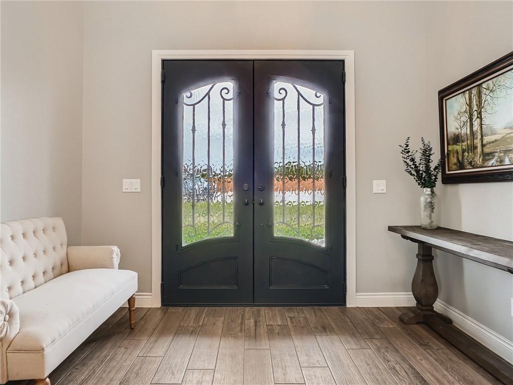 132 Huerta Road Florence, TX 76527 - Photo 3 of 40 Elegant arched iron-frame doors open to a welcoming entryway with durable wood-look tile flooring.